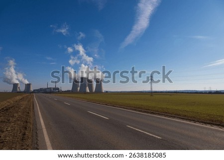 Dukovany Nuclear Power Plant in the Czech Republic, Europe. Smoke cooling towers. There are clouds in the sky. In the background the nature of the Highlands.