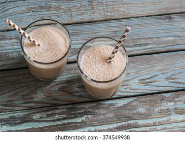 Dulce di leche and ice cream milkshake in glasses on a wooden rustic background