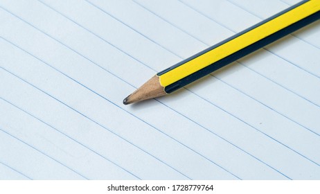 A Dull Pencil On Blank White Note Book