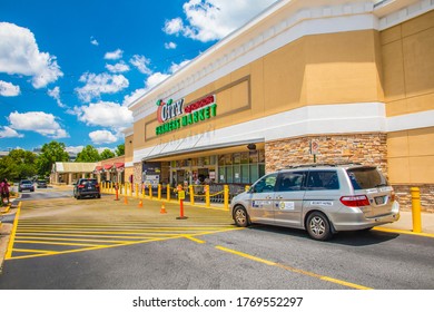 Duluth, Ga USA - 05 31 20: Peach City Farmers Market Retail Grocery Store Security Van Parked In Front Of The Building With Yellow Caution Tape To Keep People Safe During The Covid-19 Pandemic 