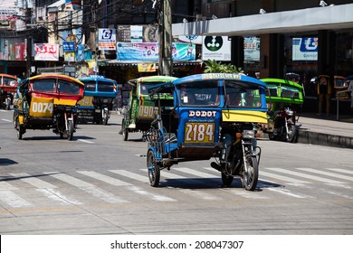 DUMAGUETE, PHILIPPINES - FEBRUARY 18, 2014 :Tricycle motor taxi, Philippines inexpensive transport service. Tricycle motor taxi are the most popular means of public transportation in the Philippines.