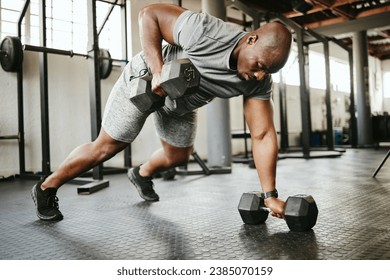 Dumbbell, fitness and bodybuilder black man with workout training in gym or garage studio for wellness, body goal and motivation. Power, strong and african sports man doing push up exercise with gear - Powered by Shutterstock