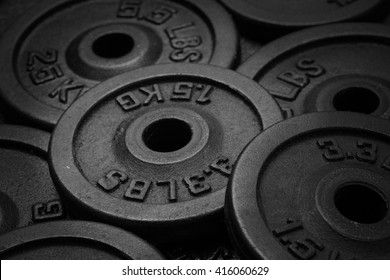 dumbbell and iron plates black and white