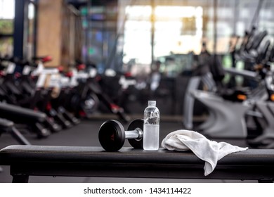 Dumbbell, Water Bottle, Towel On The Bench In The Gym.