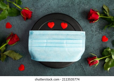 Dumbbell Weight Plate In Face Mask COVID-19 Coronavirus, Red Roses. Love Gift For Valentine's Day, Birthday, Anniversary, Wedding. Lockdown Home Gym Workout, Fitness Exercise Flat Lay Composition.