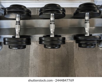 Dumbbells set left on the racks in the gym.