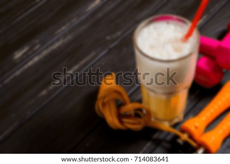 Dumbbells, skipping rope and protein blurred abstract background