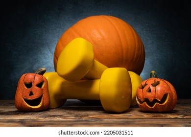 Dumbbells with two small ceramic Halloween pumpkins. Healthy fitness lifestyle autumn or fall composition. Decorative Jack-o'-lantern spooky figurine heads. Gym workout and sport training concept. - Shutterstock ID 2205031511