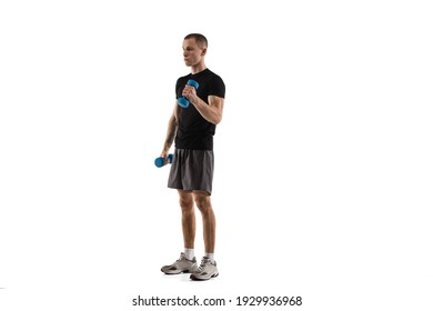 Dumbbells. Young caucasian male model in action, motion isolated on white background with copyspace. Concept of sport, movement, energy and dynamic, healthy lifestyle. Training, practicing. Authentic.