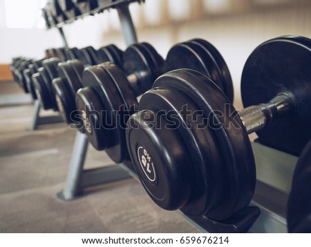 Dumbells set left on the racks in the gym.