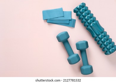 Dumbless, foam roller and fitness tapes on pastel pink background.  Sport workout equipment, top view. - Shutterstock ID 2127781532