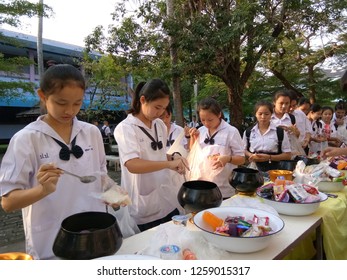 Dumnoensaduak, Ratchburi/Thailand - Dec. 4, 2018 : Thai Students In Secondary School Offering Food To The Monk Alm Bowl For Buddhist Monks, Making Merit For Their Fathers On Fathers Day