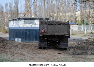 Dump Truck With A Full Body Of Cut Tree Branches. Cleaning City Streets From Broken Branches After A Hurricane. View Of The Truck From The Side Tailgate. Real City Life. Selective Focus. Without