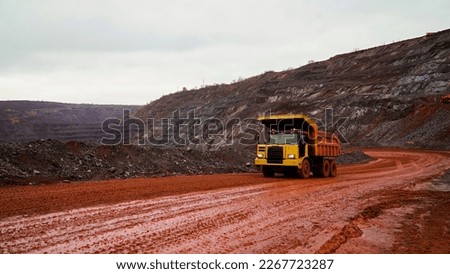 dump truck transporting iron ore in red iron ore quarry. The red quarry looks like the planet Mars         