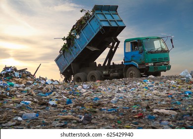 Dump truck unloading waste on a landfill - Shutterstock ID 625429940