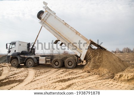 dump truck at work on a construction site. Soil unloading process. Excavation