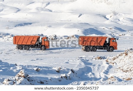 Dump Trucks on the Background of a Snowy Landscape in Winter