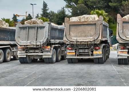 Dump Trucks at a road construction site carrying heavy boulders