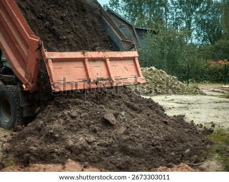a dumper offloading dirt, blurred motion shot, no people
