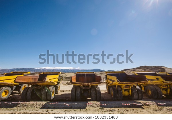 Dumper trucks\
parked on a construction\
site.