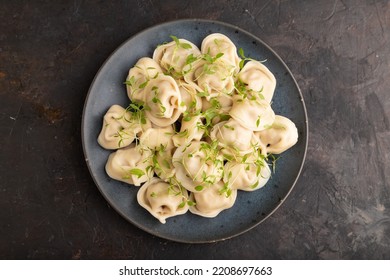 Dumplings With Pepper, Salt, Herbs, Microgreen On Black Concrete Background. Top View, Flat Lay, Close Up.