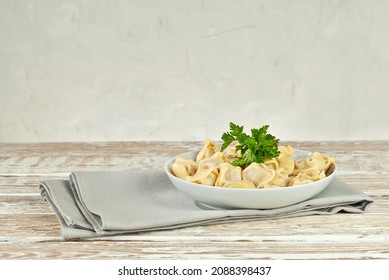 Dumplings in a white plate on an old shabby table. Dumplings with yellow dough close up. Food on a white board background. Copy space and free space for text near the plate. - Shutterstock ID 2088398437