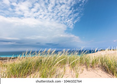 Dune Grass Sways In The Breeze Under A Blue Sky With Dramatic White Clouds Streaking Overhead At Sleeping Bear Dunes National Lakeshore In Glen Haven Michigan