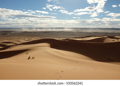 Dune Landscape Of Sahara Desert With Dust Storm In The Distance
