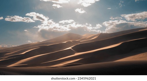 dunes in the desert with a cloudy day, blue sky and foot prints. - Powered by Shutterstock
