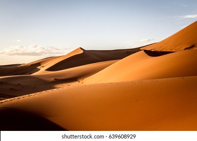 Dunes with tracks in the Sahara desert in Morocco with cloudy sky