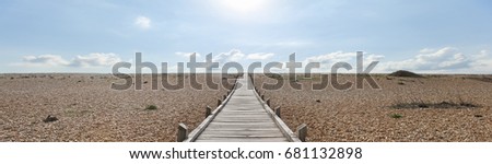 The Dungeness headland in Kent is the only area in Britain that could be considered desert.  This windswept and forlorn location has this wooden plank path leading across the shingle to the sea.