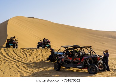 DUNHUANG, GANSU, CHINA - OCTOBER 25, 2017: Quad Bike And Dune Buggy Parked In Gobi Desert With Dunes Background In Dunhuang, China