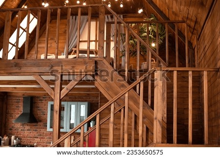 Duplex house with living room, kitchen, bedroom. Interior wooden house on two levels. Room with wooden stairway leading to second floor of modern flat. Duplex house with staircase with steps