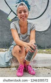 Duque De Caxias, Rio De Janeiro, Brazil -  December 10, 2018: Brazilian Curly Girl, Woman Artist  Holding Spray Can Aerosol Smiling, Painting In Slum