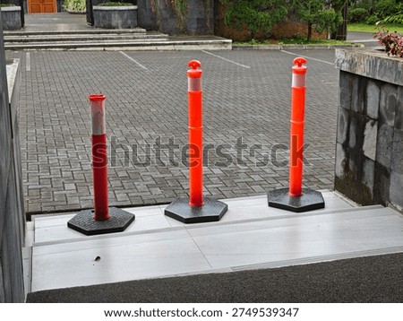 Durable orange traffic delineator posts with reflective strips and heavy-duty hexagonal bases. High-visibility safety bollards for parking lots, road construction, and crowd control.