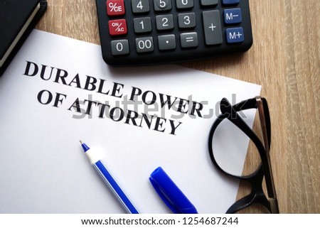 Durable power of attorney document, pen, glasses and calculator on desk