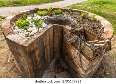 Durable raised bed with an opening for a composter and vegetable scraps, covered with raw sheep wool as mulch that suppresses weeds