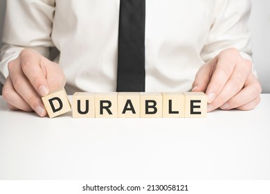 durable word written on wood block. durable motivation text on wooden blocks business concept white background. Front view concepts, flower in the background