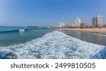 Durban beachfront clear blue ocean sea waters along beach coastline with public piers jetty