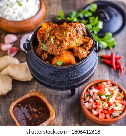 Durban Lamb Curry in potjie pot surrounded by ingredients