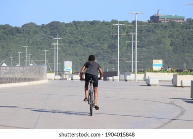 Durban, South Africa - 28 January 2020: Photo Of A Young African Boy Cycling On The Promenade