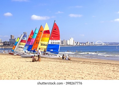 DURBAN, SOUTH AFRICA ; MARCH 28, 2016:Many Unknown People And Colorful Sail Boats On Vetch's Beach In Durban South Africa