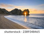 Durdle Door sunburst through the arch on winters morning on the Jurassic coast of Dorset