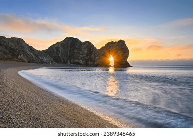 Durdle Door sunburst through the arch on winters morning on the Jurassic coast of Dorset - Powered by Shutterstock