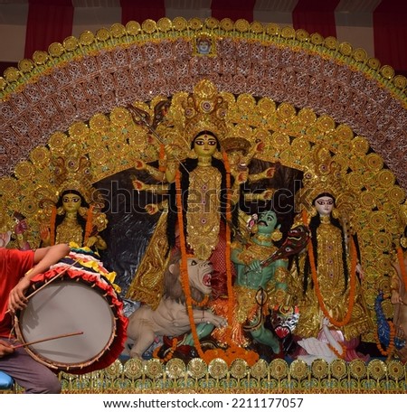 Durga puja dhak - Side angle shot of Dhaki or drummer playing Dhak  in Durga pooja festival.
