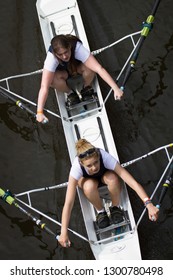 Durham / Great Britain - June 14, 2014: Two Female Rowers In Race With One Looking Up To Camera.  Overhead Shot.