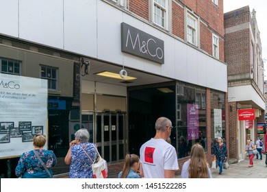 Durham, UK - 14th July 2019: M & Co In The City Centre Of Durham Exterior. The Shop Is Moving From Its Place In Prince Bishops To Its New Location. Shoppers Look In The Window Of The Coming Soon Store