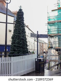 Durham, UK - Nov 2016: View Of Direction Signpost And Christmas Tree With White Fence At Street Intersection With Commercial Buildings And Renovated Building And Bright Sky Background. No People.