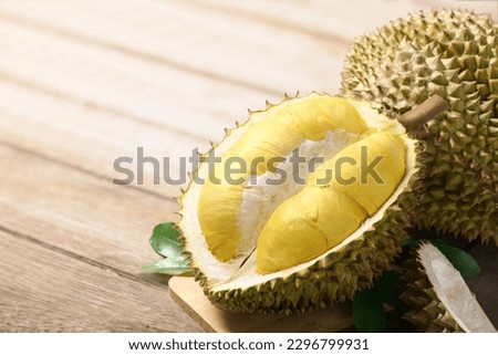 Durian fruit with cut in half on wooden table.