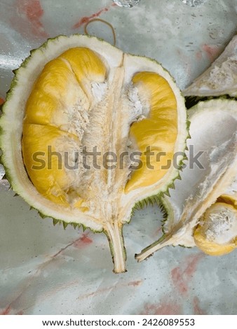 Durian fruit on marble table . split durian. Yellow Musang King durian